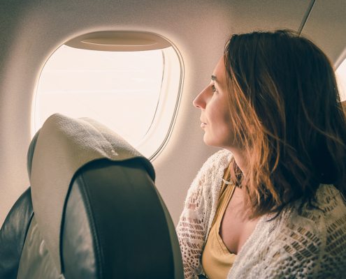 Cancer treatment radiotherapy - Traveler girl watching through airplane window