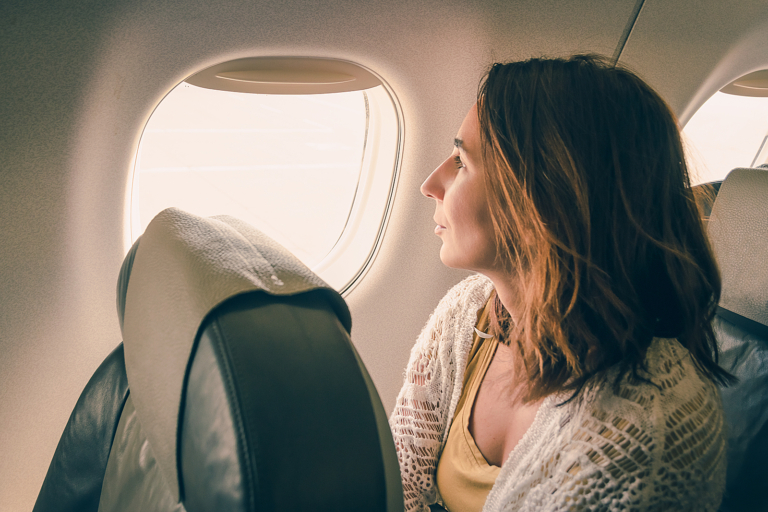 Cancer treatment radiotherapy - Traveler girl watching through airplane window