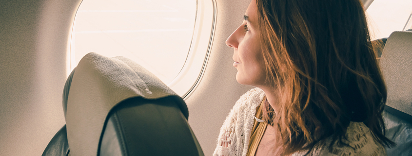 Cancer treatment radiotherapy - Traveler girl watching through airplane window