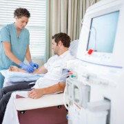 cancer treatment radiotherapy - Mid adult female nurse injecting patient for renal dialysis