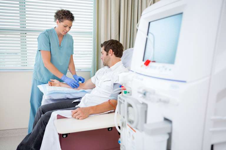 cancer treatment radiotherapy - Mid adult female nurse injecting patient for renal dialysis