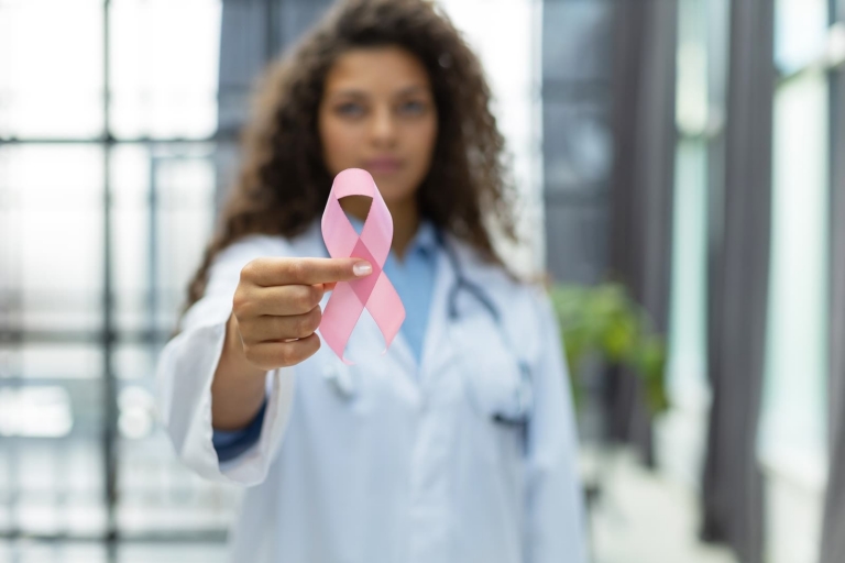 Radiotherapy centre - woman with hand holding pink ribbon